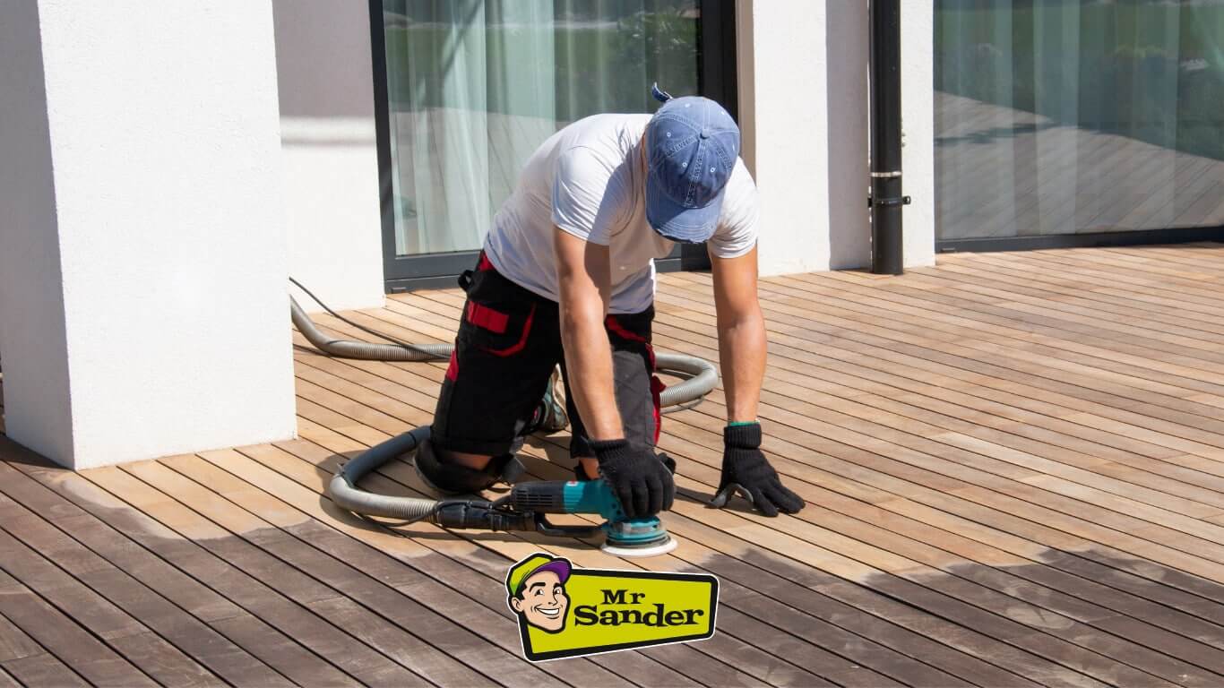 Worker using an industrial floor sander on outdoor decking.
