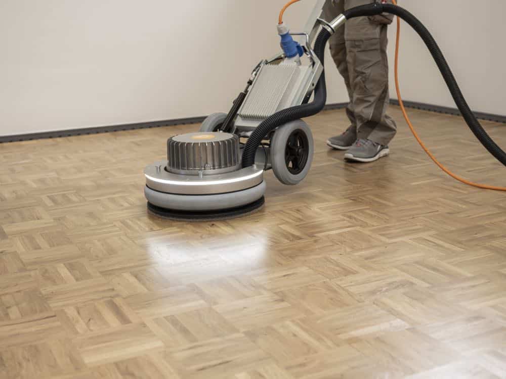 A Mr Sander® technician using a Pallmann Spider rotary sander on a wooden floor in an East London home — 230V, 2000W, 400mm sanding width, dust-free extraction