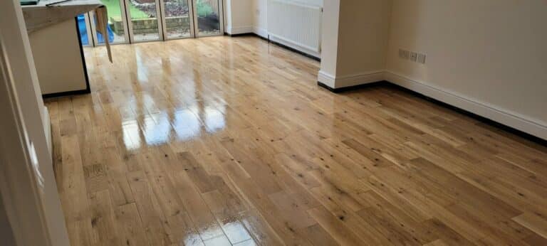 Spacious room with wide-plank oak flooring extending towards glass patio doors.