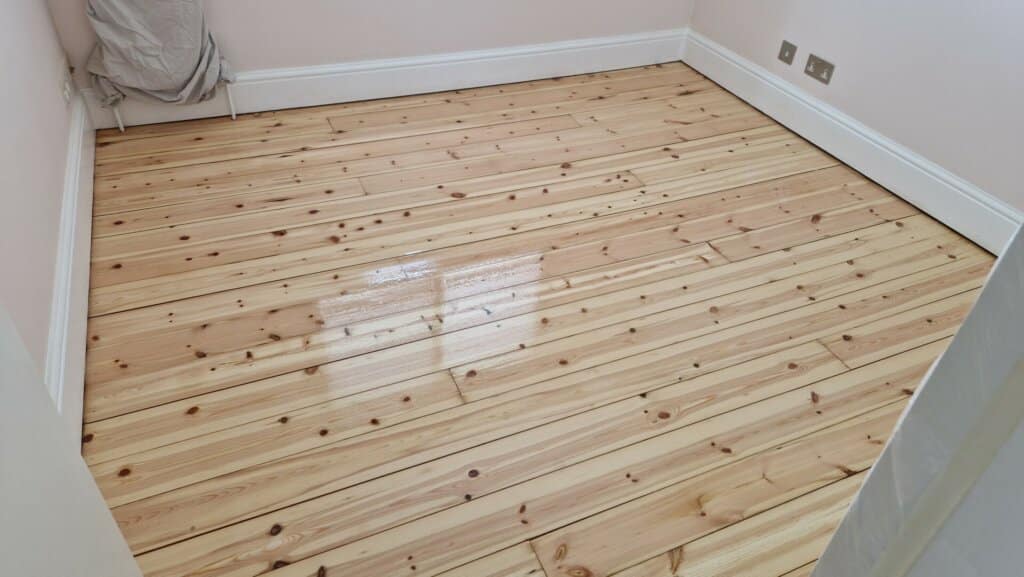 A newly sanded and refinished wooden floor in Stanmore, UK, done by Mr Sander®. The image shows a close-up view of the light-coloured, polished wooden floorboards.