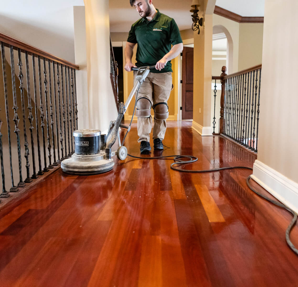 A Mr Sander® professional is sanding an oak floor in a living room in UK, using a Bona FlexiSand 1.9 (AMO310002) buffer. The machine features a 1.9 kW motor, 230 V, 50 Hz, with a 407 mm disc diameter, 147 rpm speed, 50 kg weight, and safety devices including a 16 A overload switch and thermal protection.