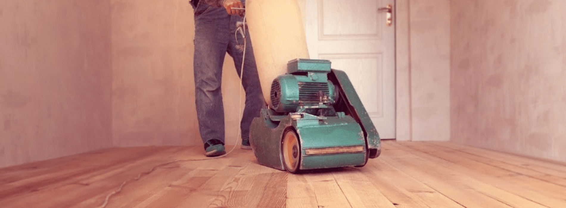 Mr Sander® skillfully sanding a herringbone floor using the powerful 2.2 kW Bona belt sander. The 220V, 60Hz machine, sized 250x750 mm, ensures exceptional results. The dust extraction system with HEPA filter guarantees cleanliness and efficiency for a flawless finish.