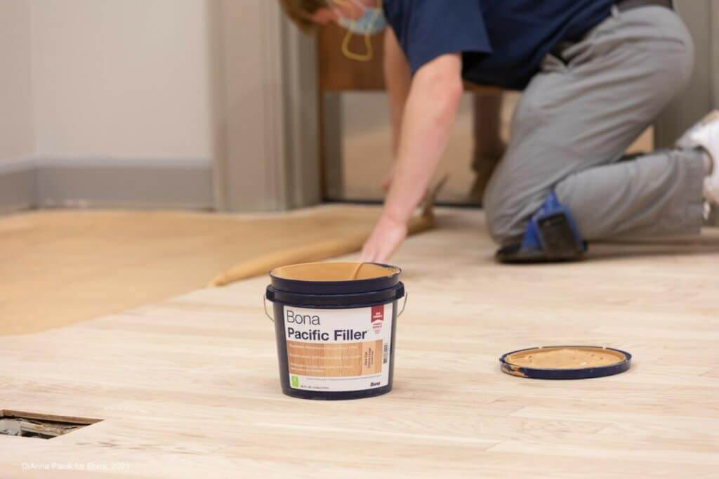 A worker using Bona Pacific Filler on a wooden floor during the floor sanding and refinishing process by Mr Sander®.