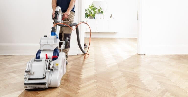 Mr Sander® are in the process of sanding a herringbone floor, employing a 250mm x 750mm Bona belt sander connected to a dust extraction system featuring a HEPA filter for a clean and efficient dust-free result.