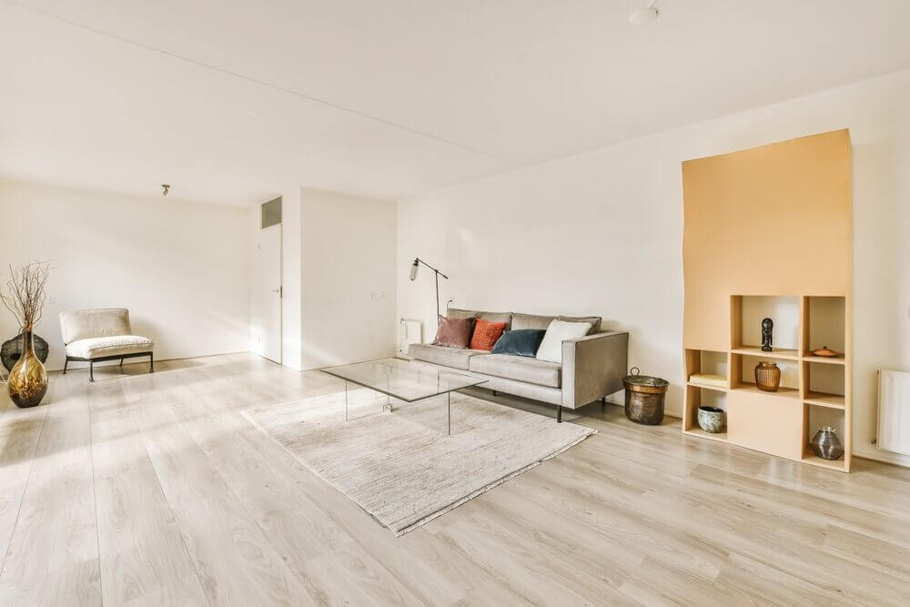 Spacious modern living room featuring pale hardwood floors, neutral furniture, and ample natural light—highlighting a floor finish suited to the “Bona White vs. Junckers Prelak” comparison.