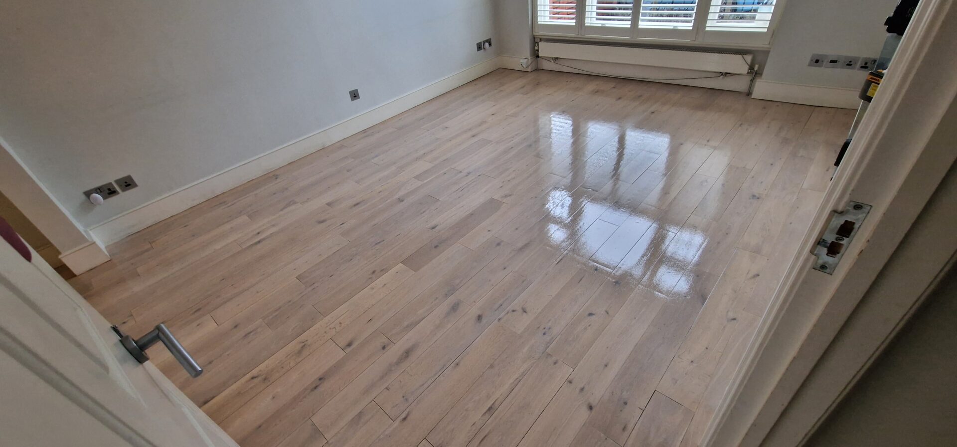 A living room wood floor with a pale, reflective finish from Bona White Primer, achieving a Scandinavian-inspired look.