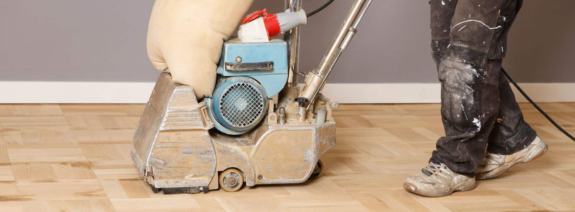In Charlton, SE7, Mr Sander® using a Bona Belt sander to sand a parquet floor. The machine runs on 2.4 kW of power and requires a voltage of 230 V with a frequency of 50 Hz/60 Hz. The sander has a size of 250x750 mm and is connected to a dust extraction system that includes a HEPA filter, ensuring a clean and efficient sanding process.