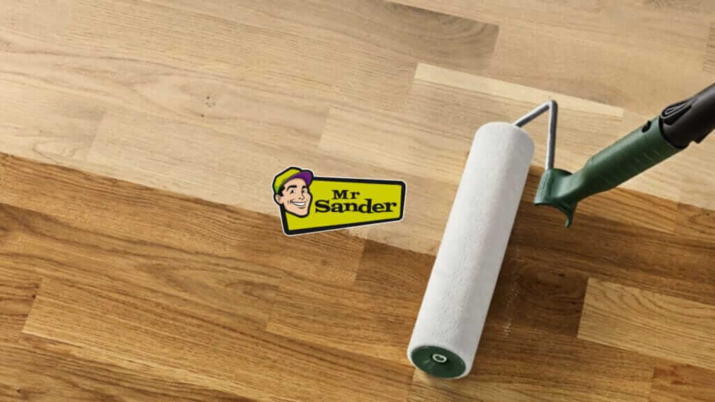 A paint roller applying a clear coat to a newly sanded hardwood floor.