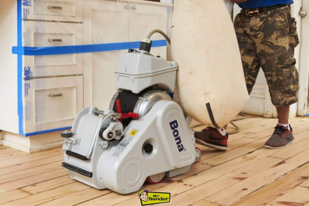 A professional Bona floor sanding machine in action, restoring a pine floor in East Twickenham, showcasing expert craftsmanship and efficient sanding techniques.