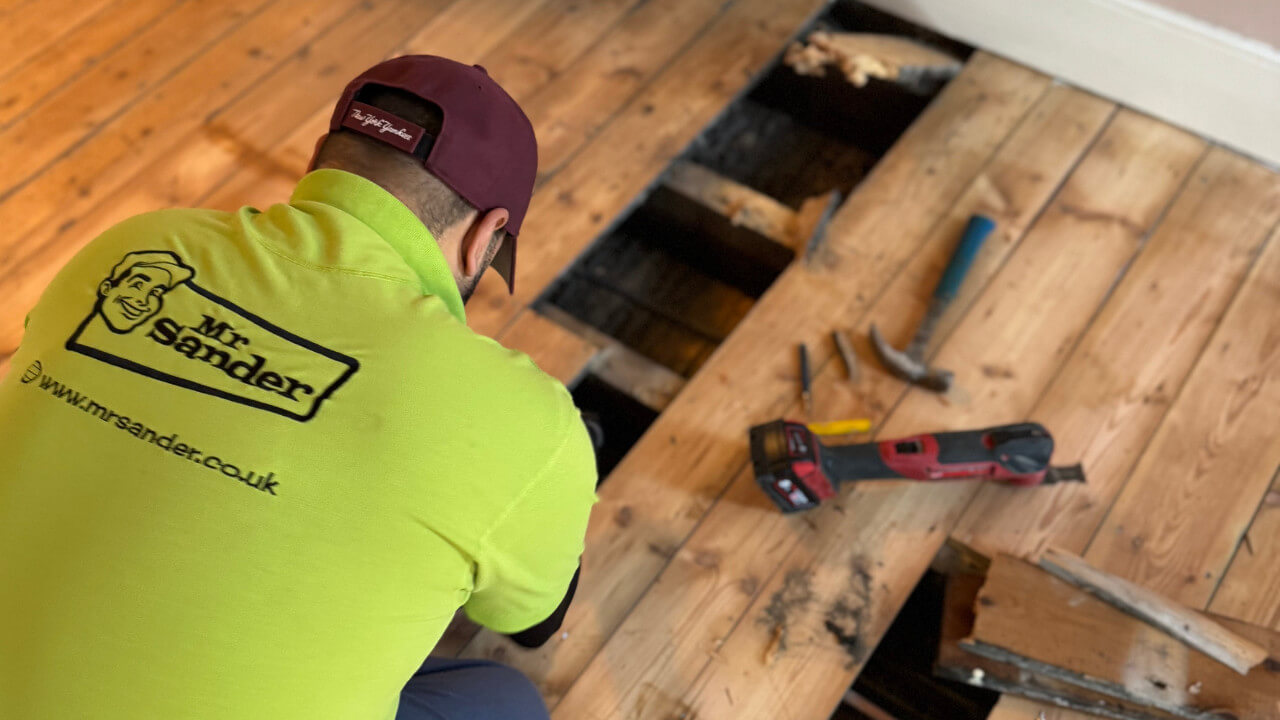 A Mr Sander® technician expertly replacing damaged boards, illustrating essential repairs to transform tired floors from worn-out to flawless.