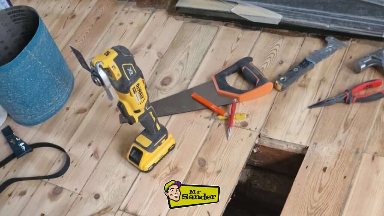 Floor repair tools and equipment, including a saw and sander, used during professional floorboard restoration by Mr. Sander in Findon.