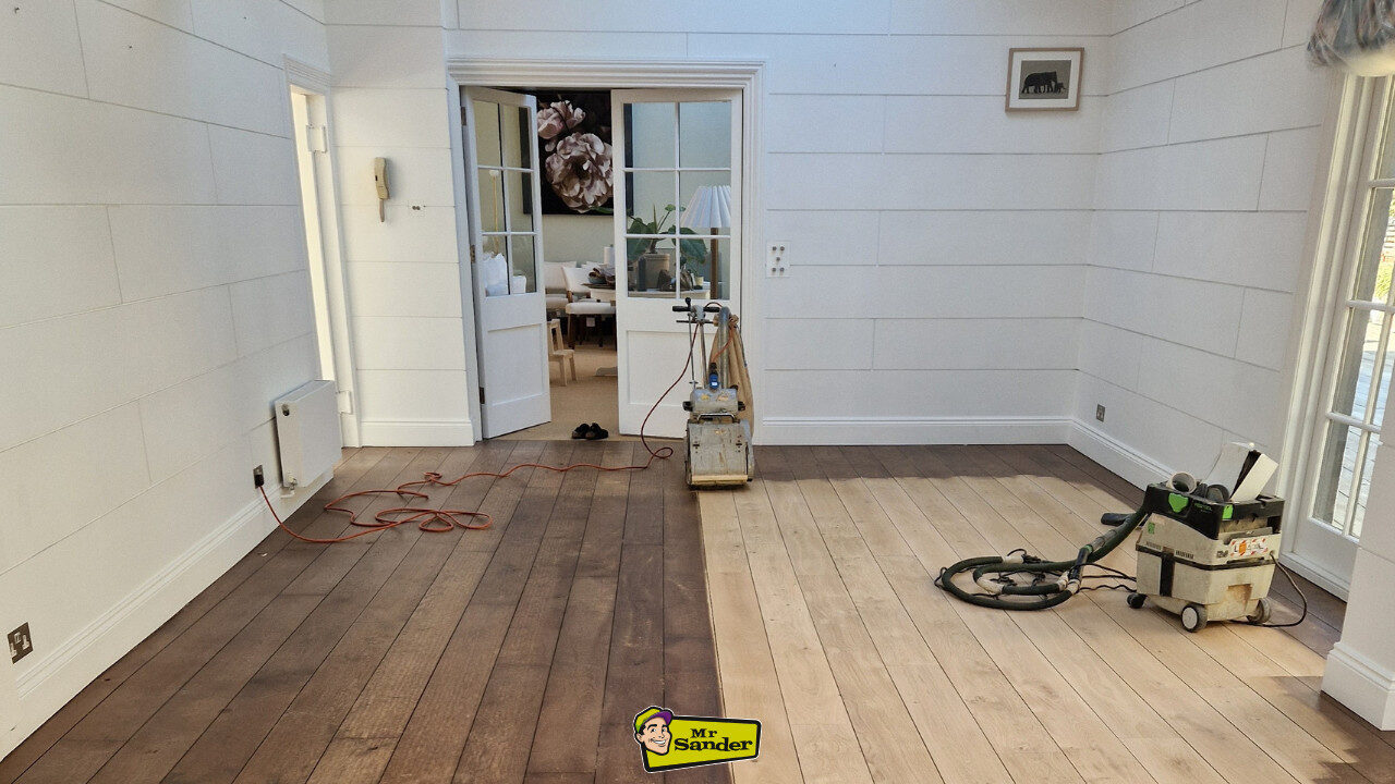 Dustless floor sanding equipment working on a partially refinished wooden floor, highlighting the dramatic results of professional Floor Care.