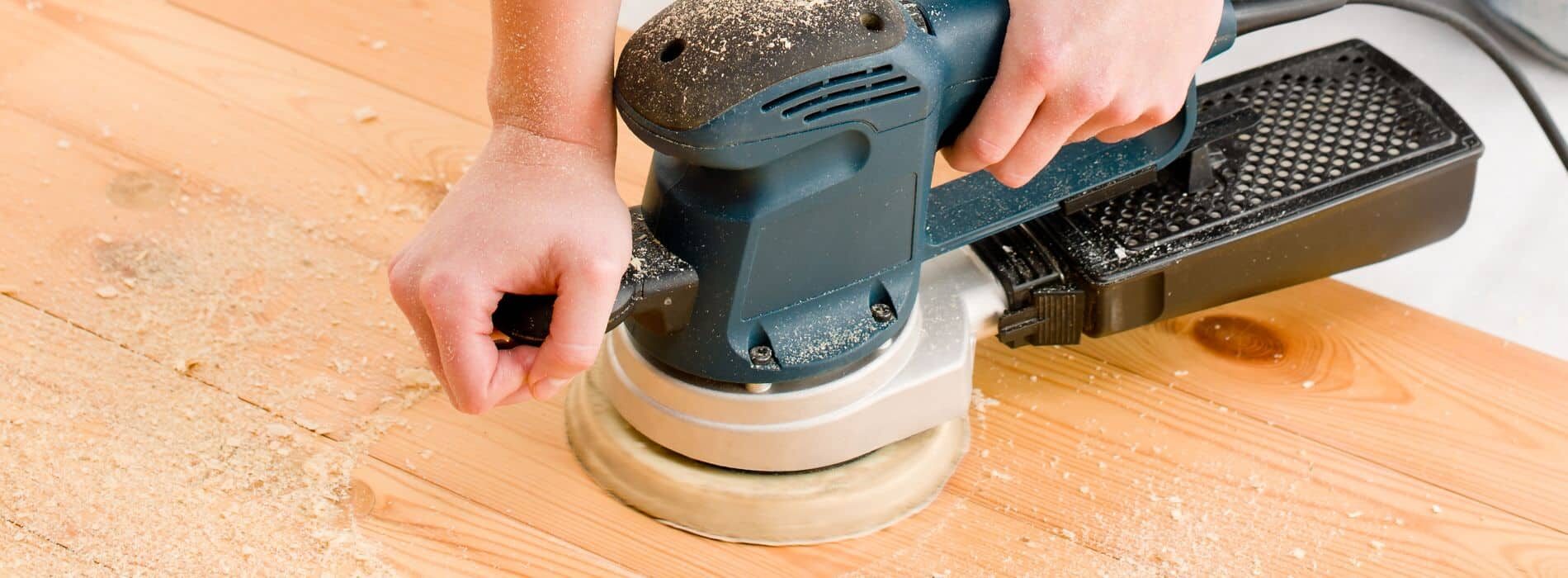 Floor sanding specialists in Catford utilise a 125mm palm sander with 80-grit sandpaper on solid pine flooring.