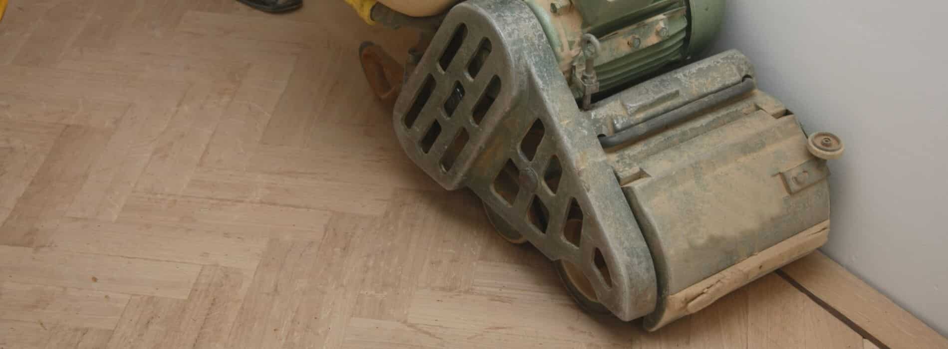 In Catford, floor sanding specialists utilise a 300mm belt sanding machine to work on a herringbone-patterned 305mm x 75mm solid pine floor.