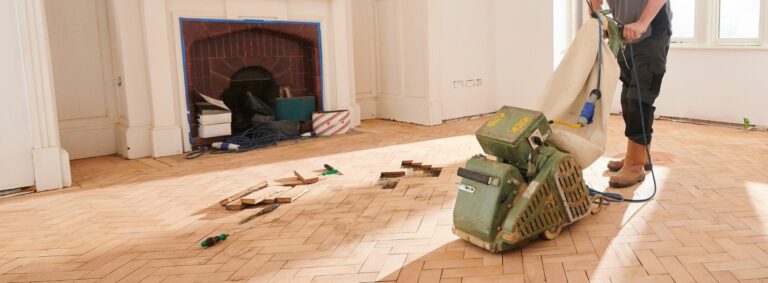 A man expertly sands an old parquet beech floor measuring 305mm x 97mm with a 25mm depth in Buckinghamshire, HP21