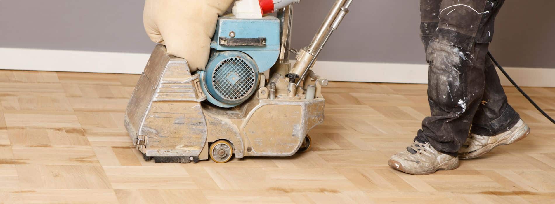 A Mr Sander® skilfully operates an Orebro 10 inch x 750mm floor sander on a 14mm 4-finger oak parquet block floor in Kingston, utilizing a medium 60 grit endless ceramic belt for optimal results and an even finish.