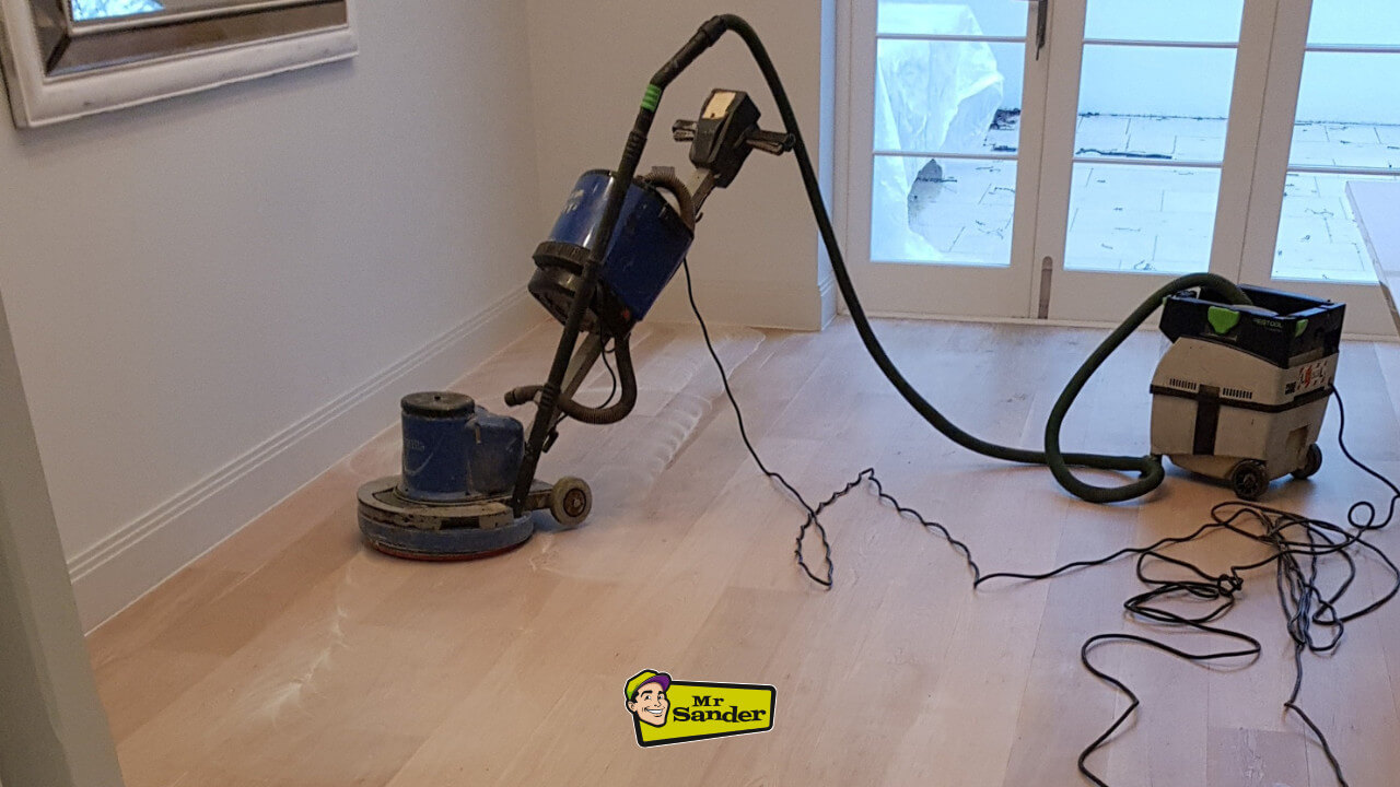 A professional floor sanding machine, operated by Mr Sander, smoothing a newly installed hardwood floor and generating typical Floor Sanding Machine Noise.