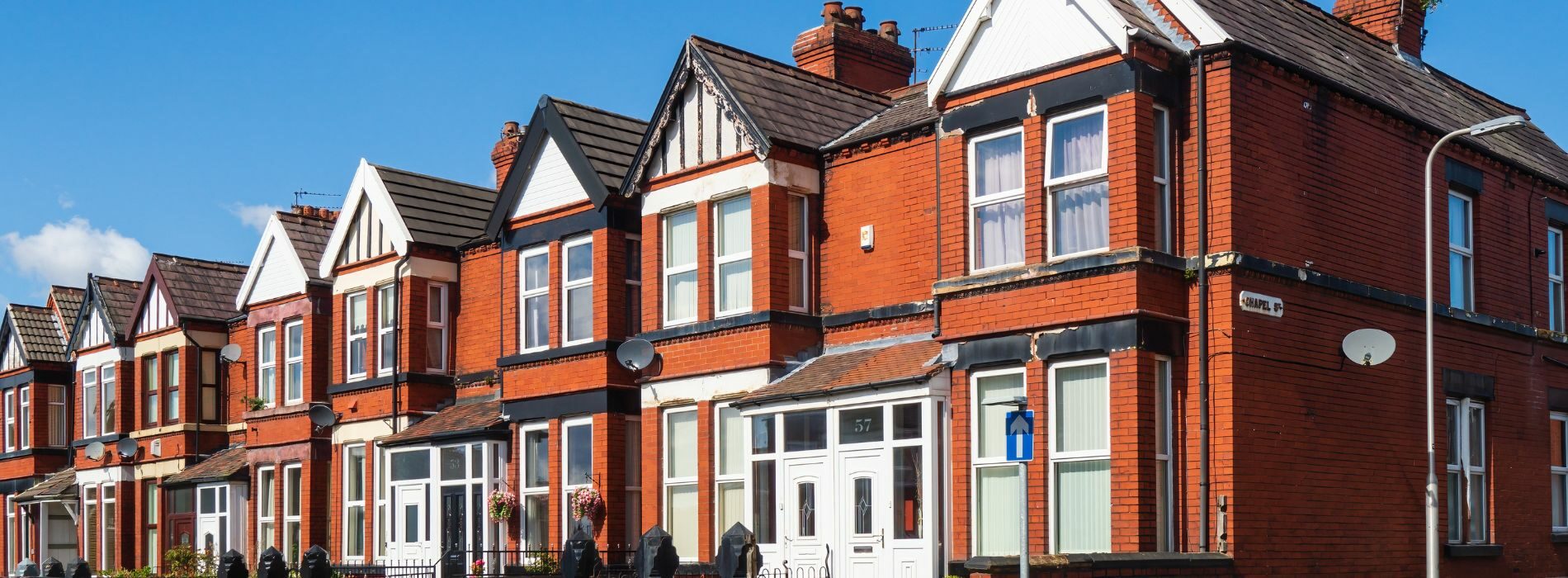 A picturesque row of red brick houses with white trim adorns the streets of Sutton, SM3.