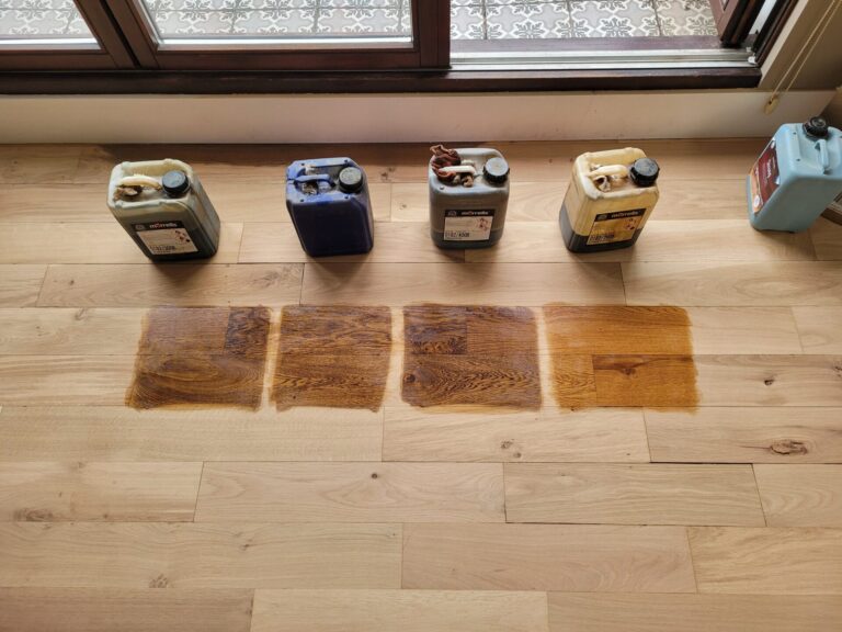 Floor sanding and dark stains applied to wooden floorboards, showcasing various stain options for creating dramatic effects in wood flooring.