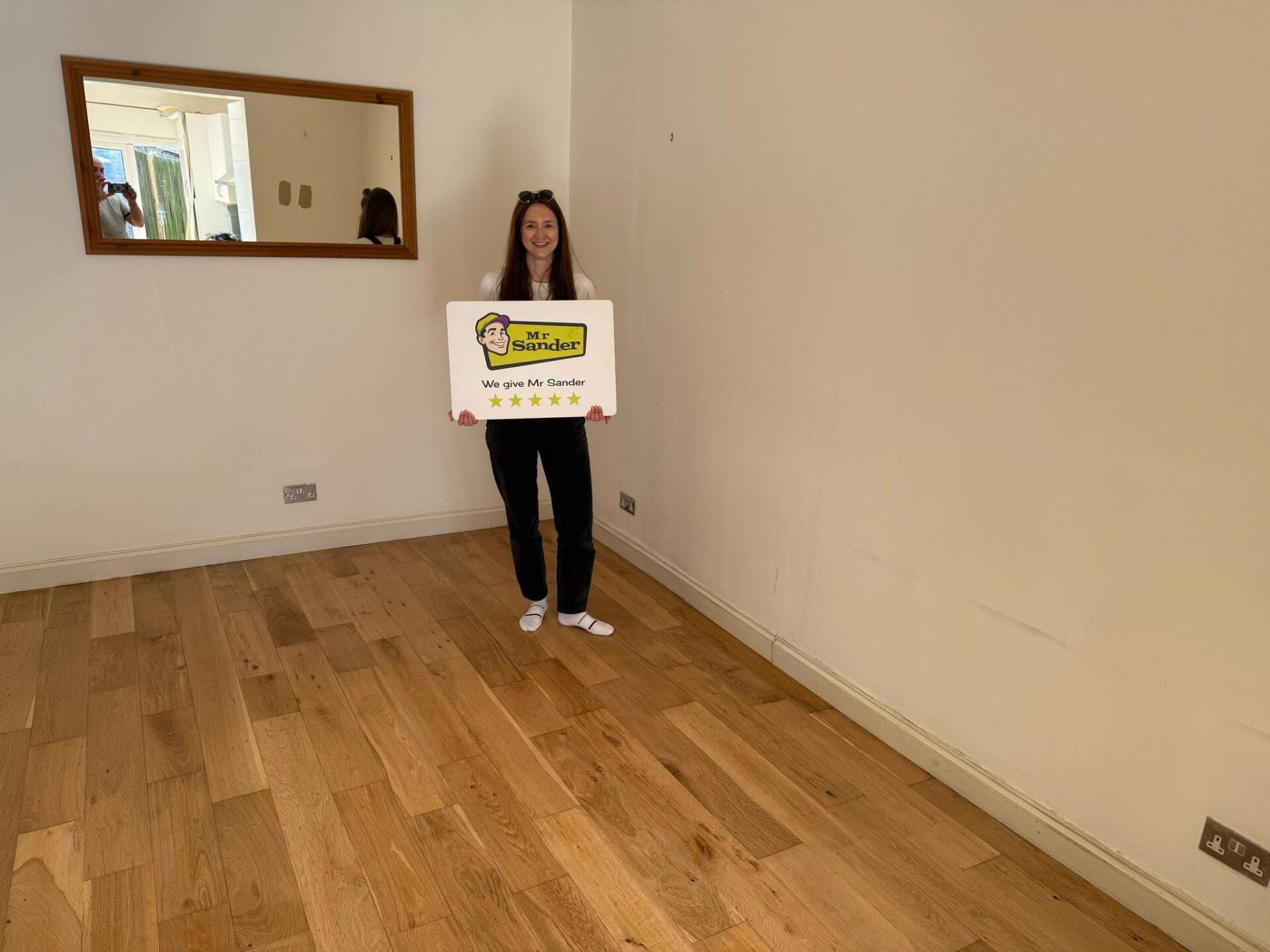 Floor Sanding and Oil Finishes: delighted customer holding a five-star Mr Sander sign on a newly oiled oak floor