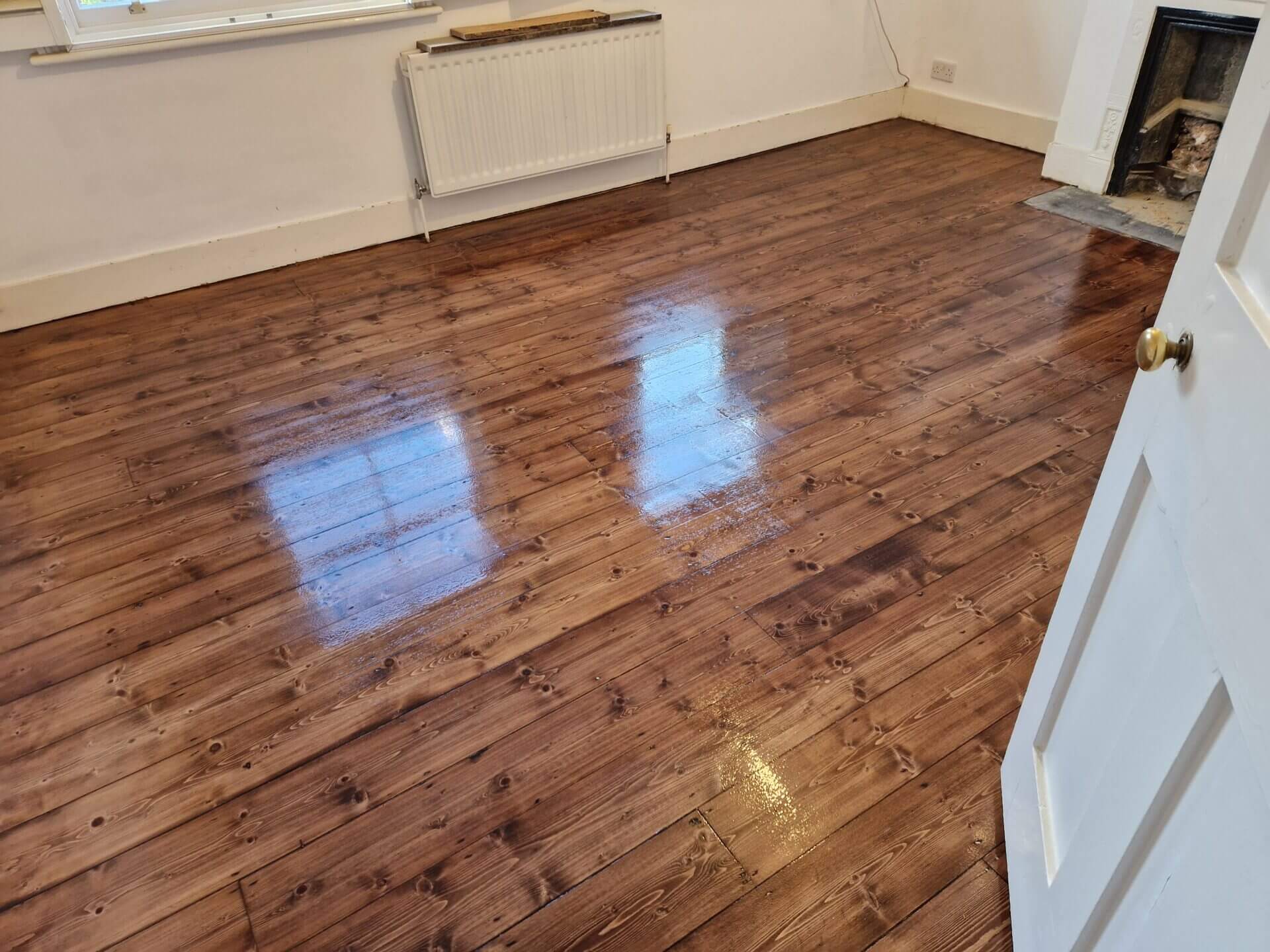 Freshly sanded wooden floor, displaying the impeccable finish achieved through floor sanding for old floors.