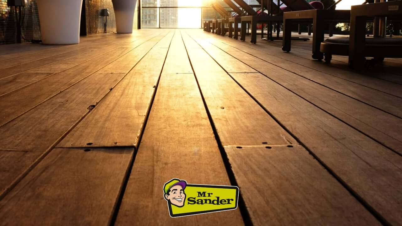 A smooth and refined hardwood deck illuminated by the warm glow of a setting sun, showcasing its natural grain and texture.