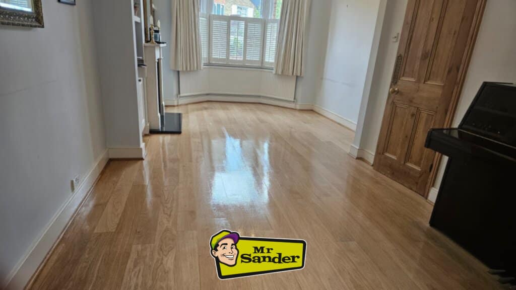 A beautifully refinished oak wooden floor in a bright living room, with Mr Sander® branding in the foreground.
