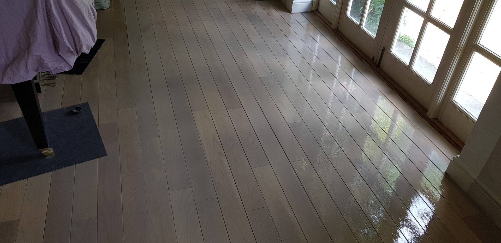 Colourful Hardwax Oils in a soft grey tone giving freshly sanded hardwood floorboards a sleek, contemporary sheen.