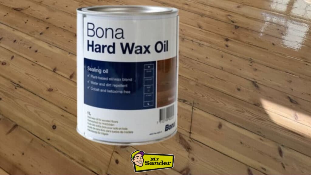 A can of Bona Hard Wax Oil on a newly refinished wooden floor. The floor appears to be made of pine.