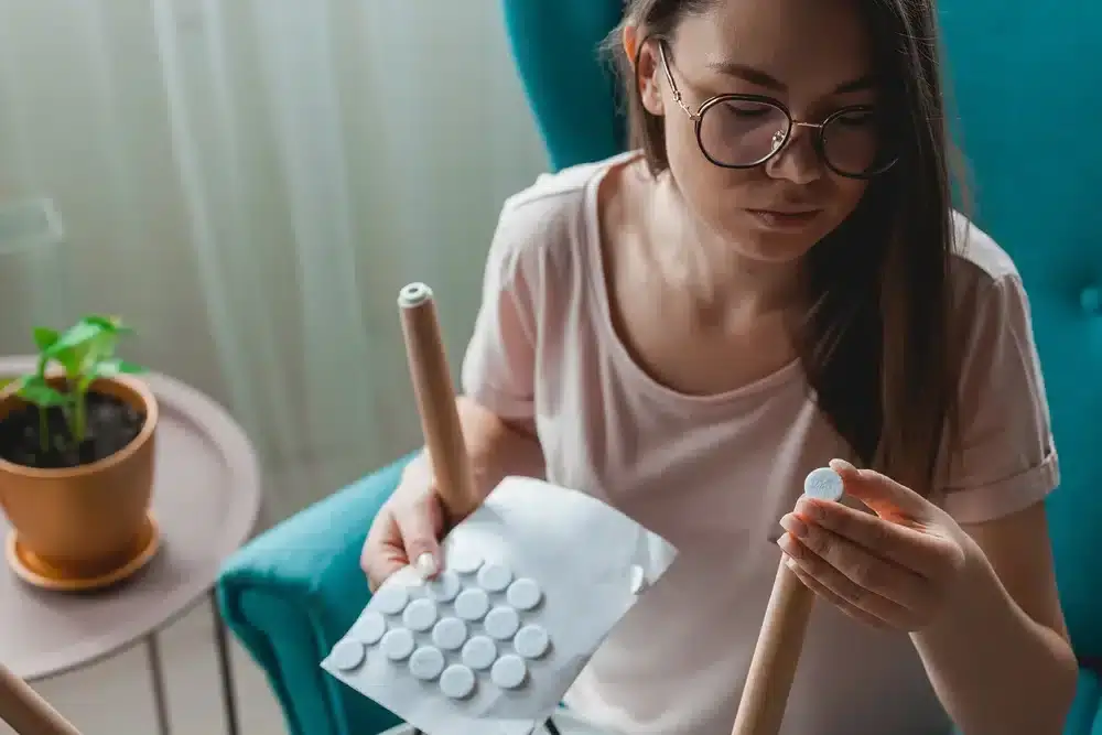 A woman applying furniture pads to protect a refinished wooden floor by Mr. Sander®.