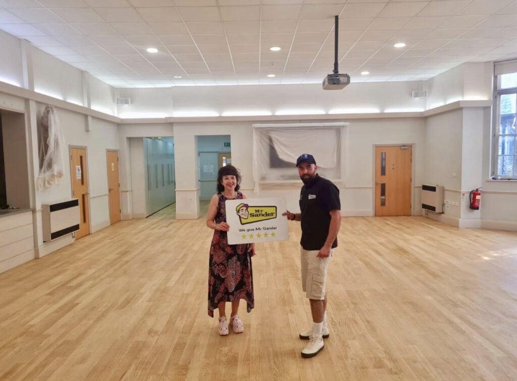 School Floor Sanding completed, happy Head Teacher posing with Mr Sander Partner.