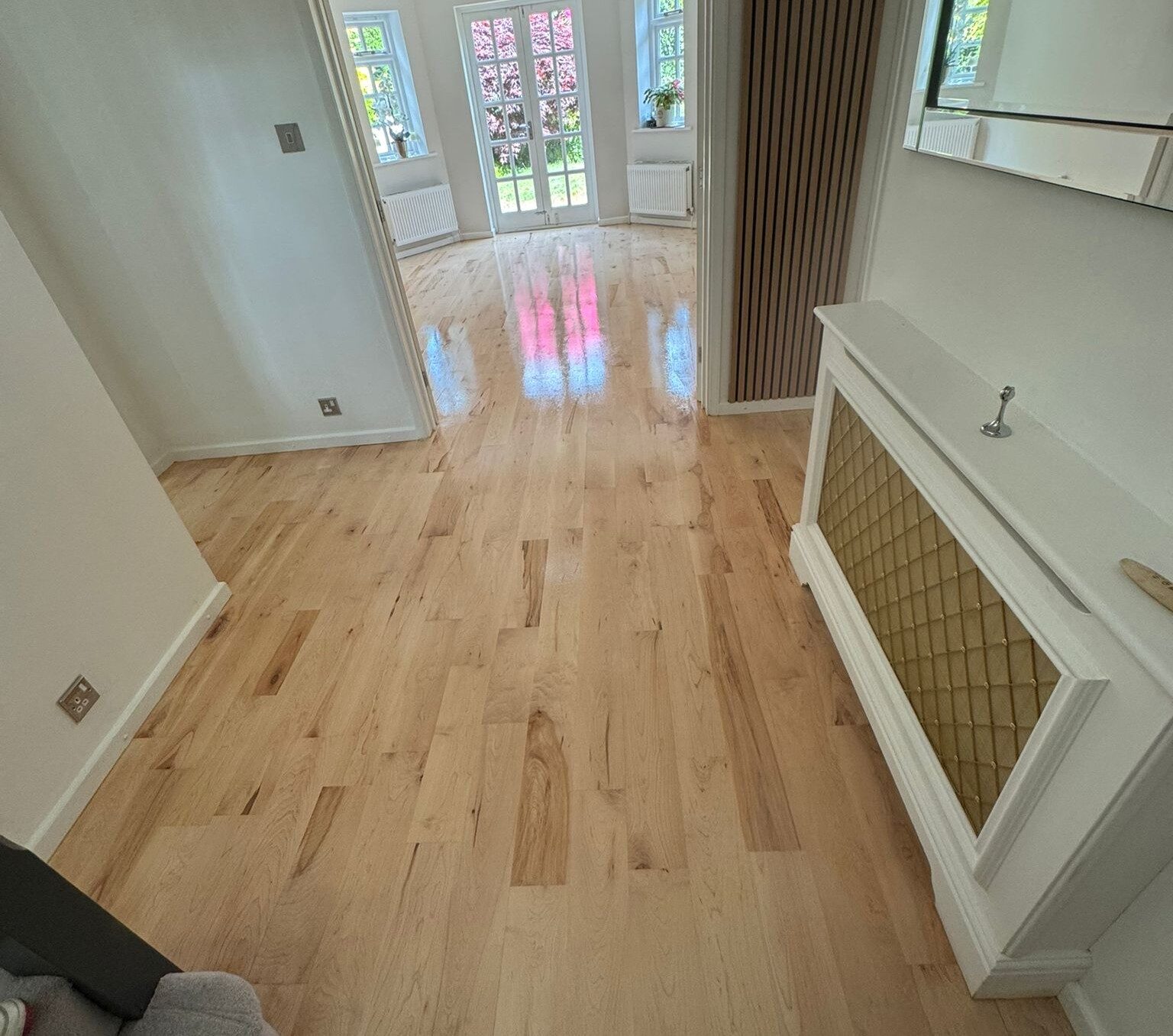 Floor Sanding and High-Gloss Finishes on a light natural oak solid wood floor running through a bright UK hallway by Mr Sander®