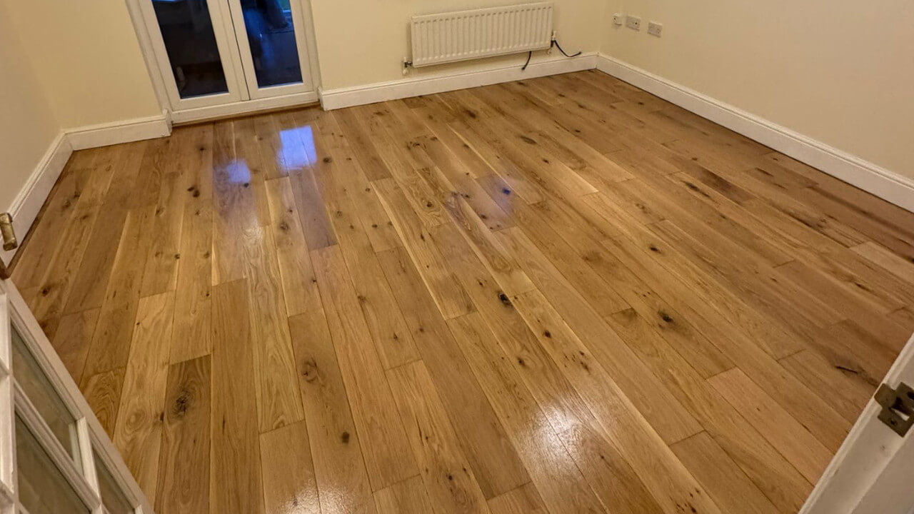 Newly finished Wooden Floors in a bright British room with patio doors