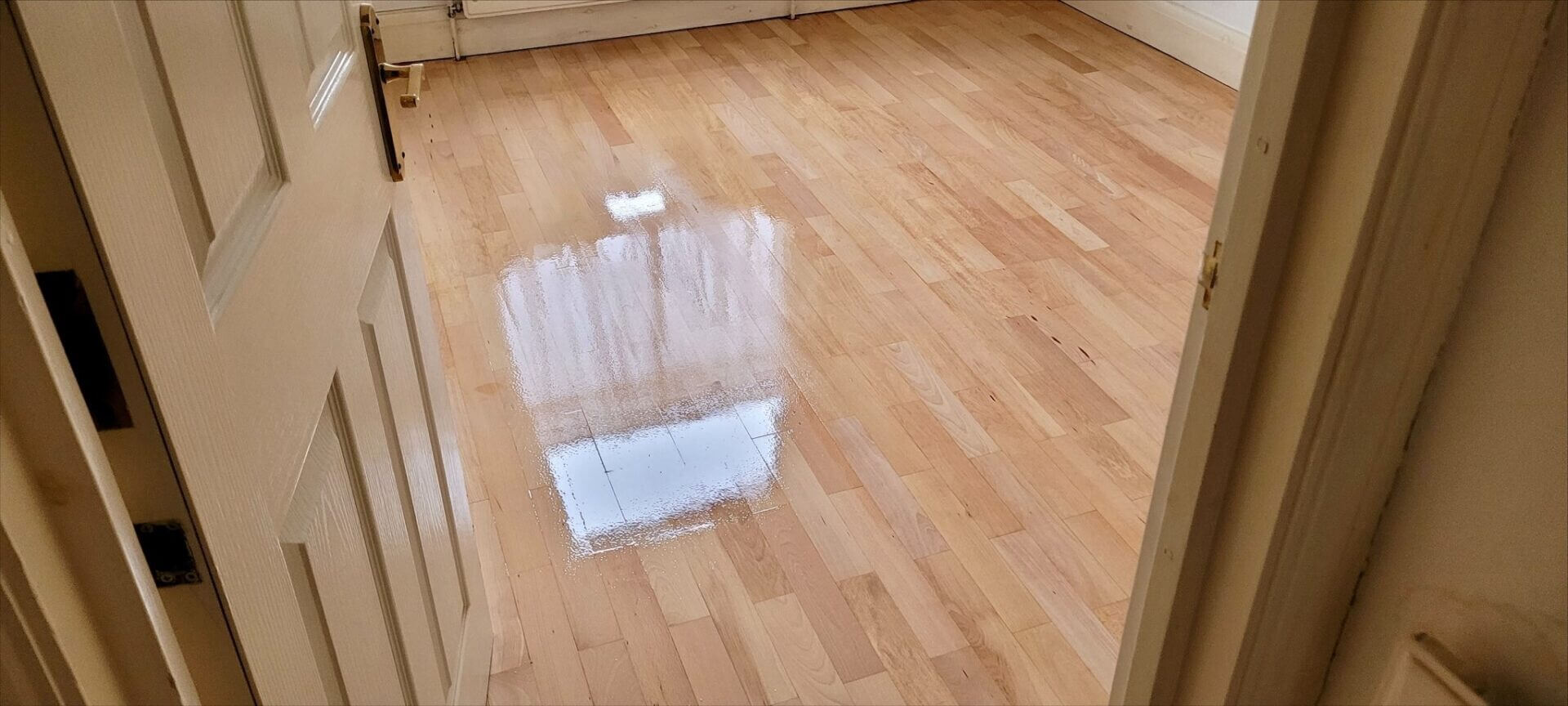 A light-colored hardwood floor after professional sanding and polishing, exemplifying expert North London Floor Fitting.
