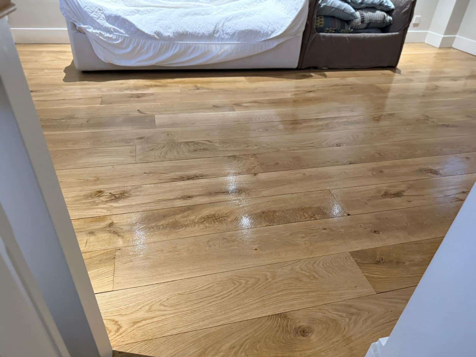 Bedroom with a newly polished Natural Hardwood Floor, showcasing warm wood grain and a slight gloss.
