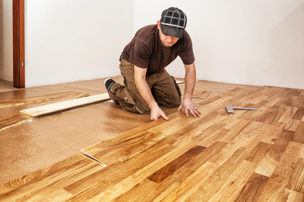 Close-up of a craftsman precisely marking an oak plank during Junckers Floor Fitting to achieve a seamless Scandinavian look.