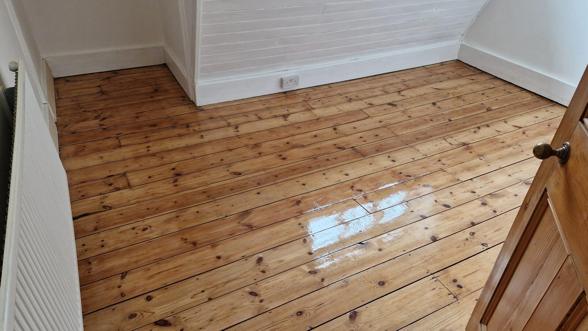Fully restored pine floor after sanding and finishing, showcasing a warm, natural grain.