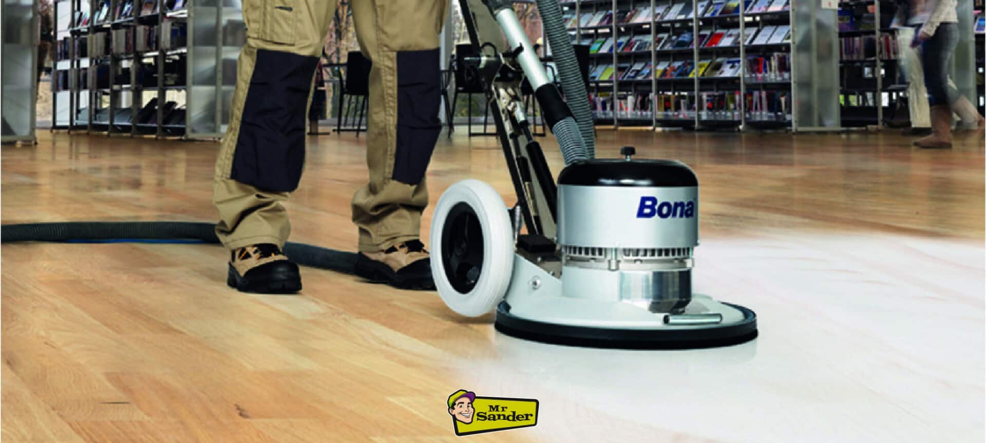 A professional floor refinisher operating a Bona buffing machine on a hardwood floor, showcasing the restoration process in a commercial setting.