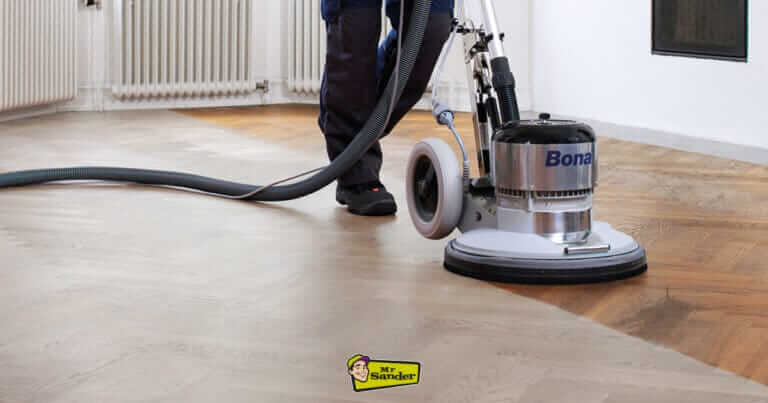 A Mr Sander professional in the UK operating a Bona FlexiSand 1.9 floor sanding machine on a herringbone parquet floor.