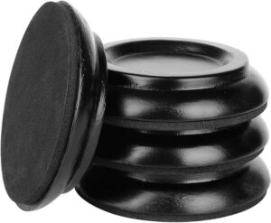 Close-up view of four black piano caster cups stacked together, with one leaning on the pile.