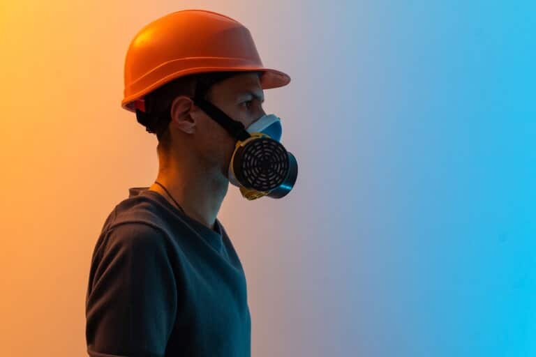 A professional wearing an orange hard hat and a respirator, essential for safety during floor sanding and refinishing.