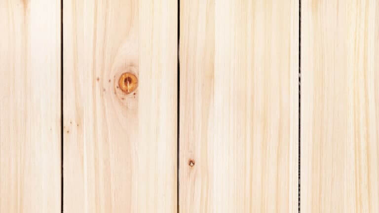 Close-up of light wooden floor planks with visible knots and grain pattern.
