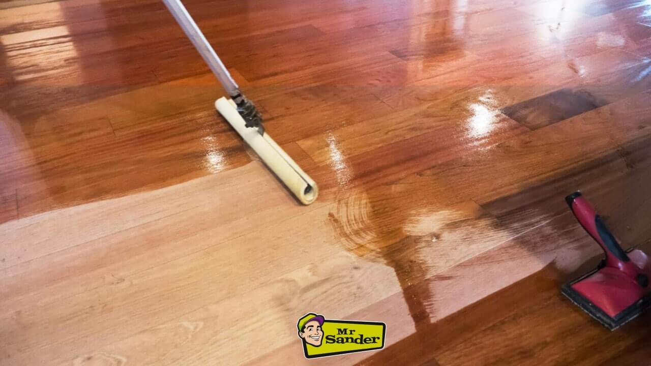 A professional applying stain to a Natural Hardwood Floor with a roller, enhancing its depth and colour.