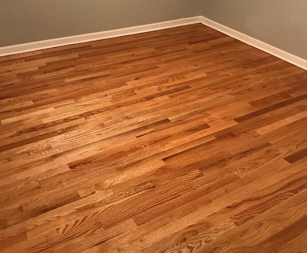 A pristine, newly refinished hardwood floor displaying a warm, rich hue—an example of The Art of Floor Sanding at its finest.