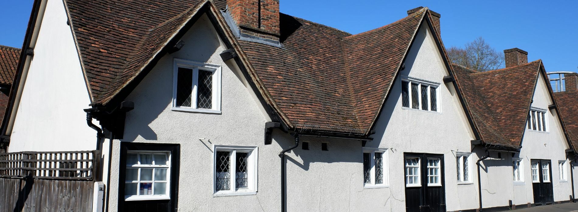 Experience the allure of charming white houses with brown roofs in Watford. 