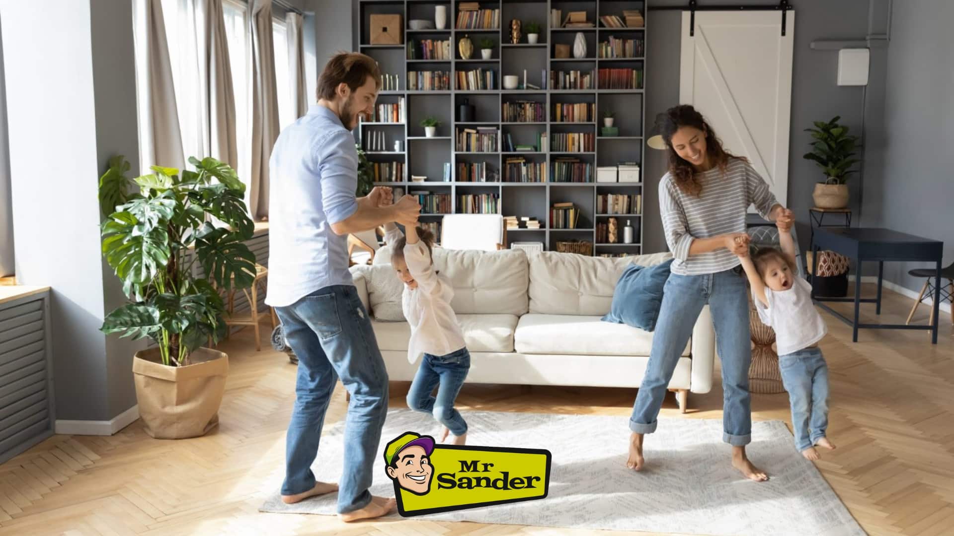 A joyful family playing in a bright, modern living room with beautifully sanded and finished wooden floors, restored by Mr Sander® in West Kensington.