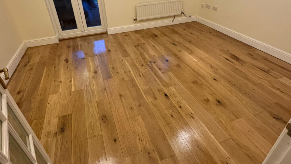 A newly refinished engineered oak floor in a living room, displaying a warm colour tone and subtle sheen.