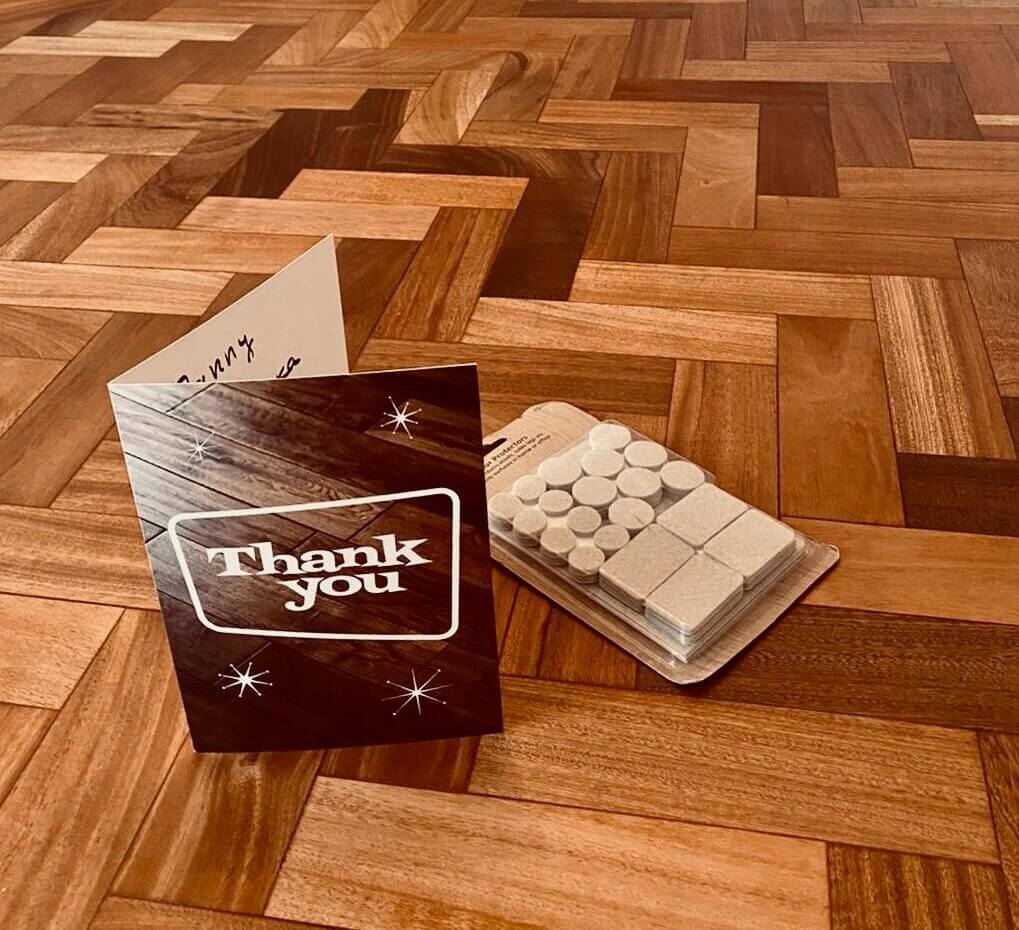 a wood floor with a thank you card and a pack of white pills
