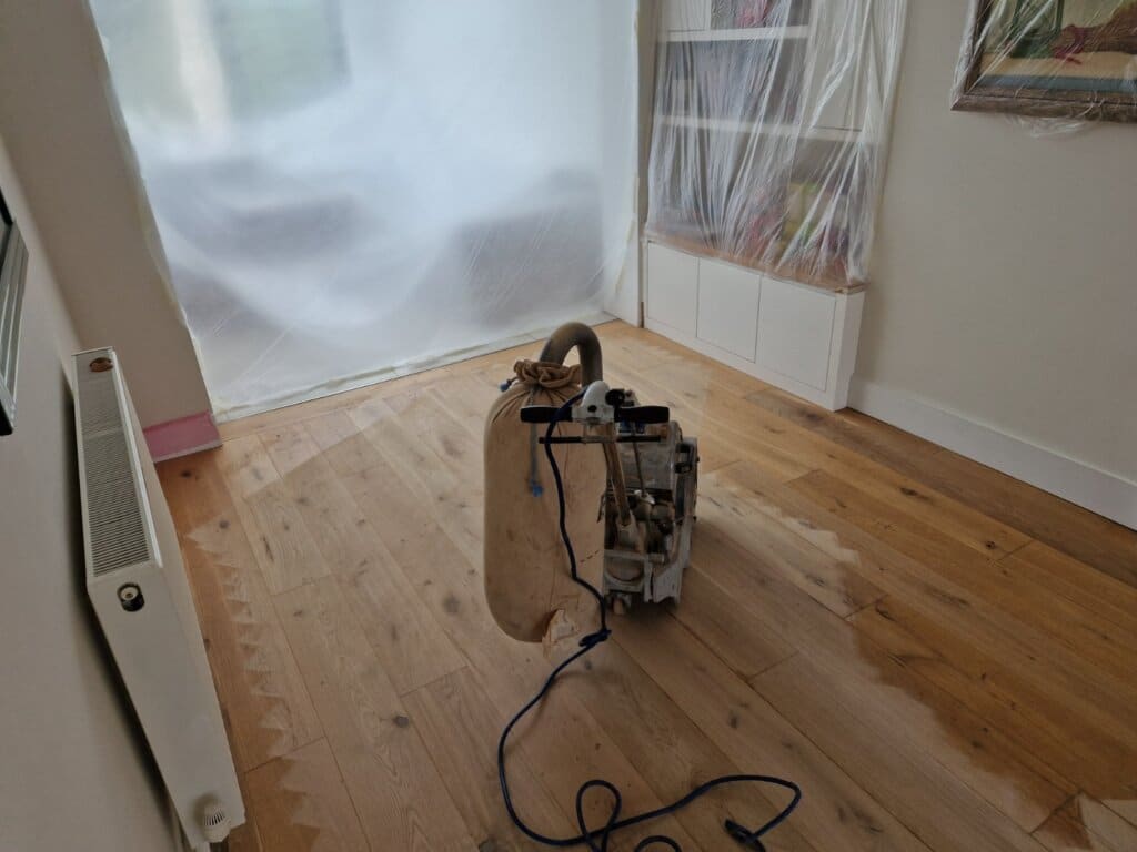 Mr Sander® professional machine is sanding a pine floor in, UK living room using a Bona Belt sander (AMO110000.3). The machine features a 2.2 kW motor, 230 V voltage, 50 Hz frequency, and a sanding belt size of 200 x 750 mm or 250 x 750 mm. The total weight is 74 kg.