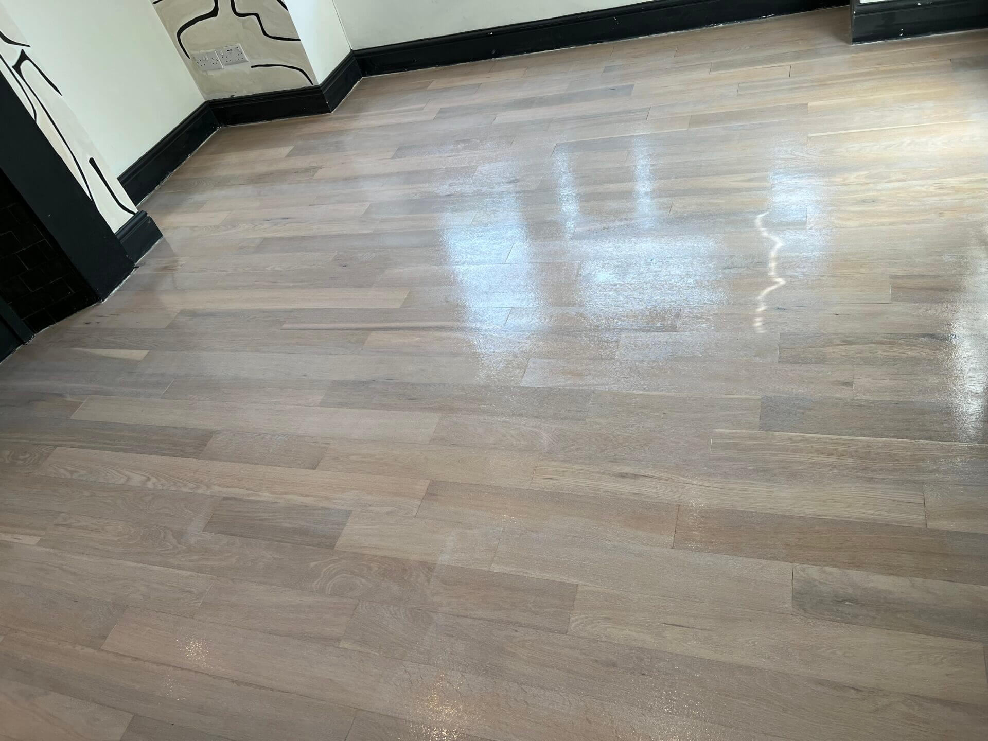 Whitewashing Floors applied to a wooden floor, showcasing a semi-gloss finish that brightens the space while highlighting the natural woodgrain.
